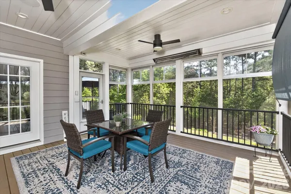 a dining room with furniture a rug and a large window