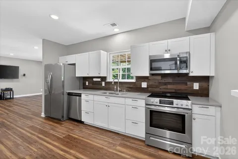 a kitchen with stainless steel appliances a stove a sink and a microwave