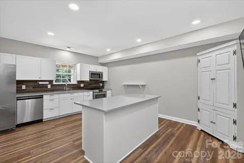 a kitchen with white cabinets and appliances