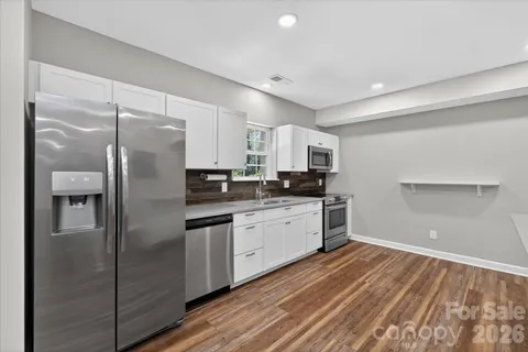 a kitchen with stainless steel appliances a refrigerator sink and microwave