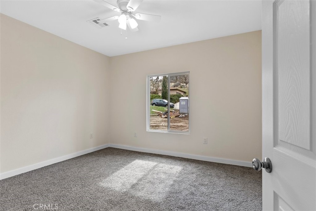 28551 Delaware Drive Tehachapi, CA 93561 - Photo 17 of 34 an empty room with windows and chandelier fan