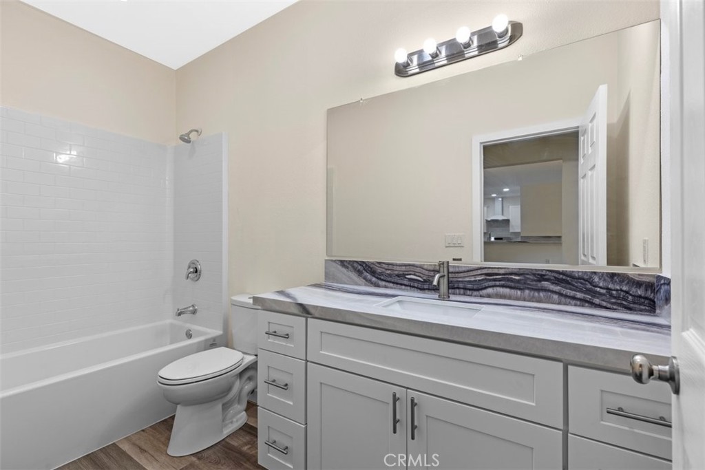 28551 Delaware Drive Tehachapi, CA 93561 - Photo 20 of 34 a bathroom with a granite countertop sink a toilet and a bathtub