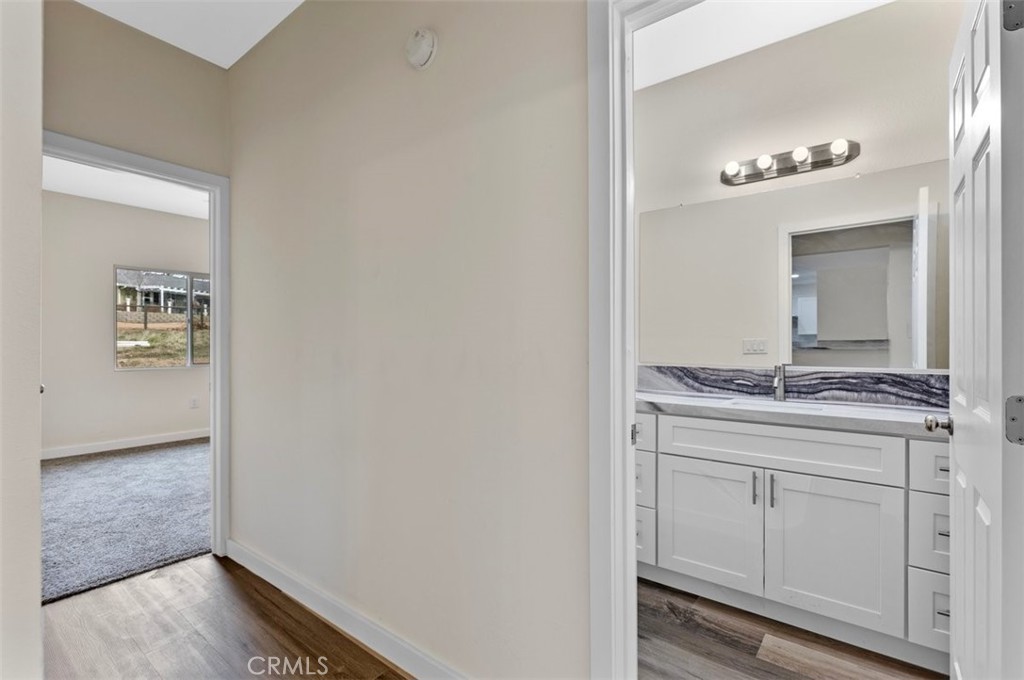 28551 Delaware Drive Tehachapi, CA 93561 - Photo 22 of 34 a bathroom with a granite countertop sink and a mirror