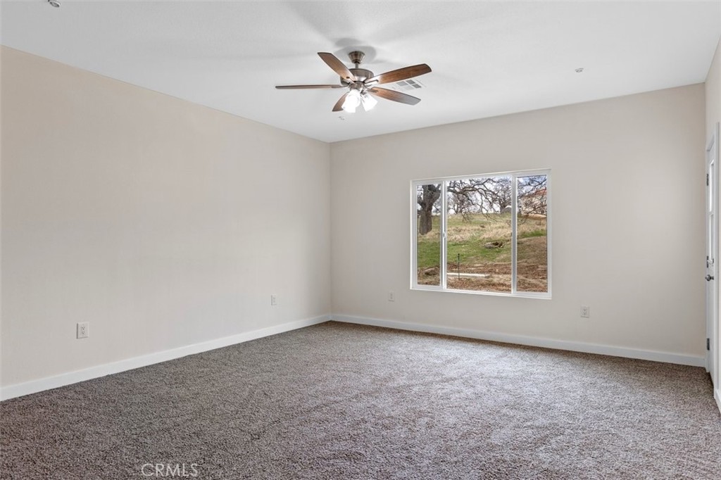 28551 Delaware Drive Tehachapi, CA 93561 - Photo 24 of 34 an empty room with windows and ceiling fan