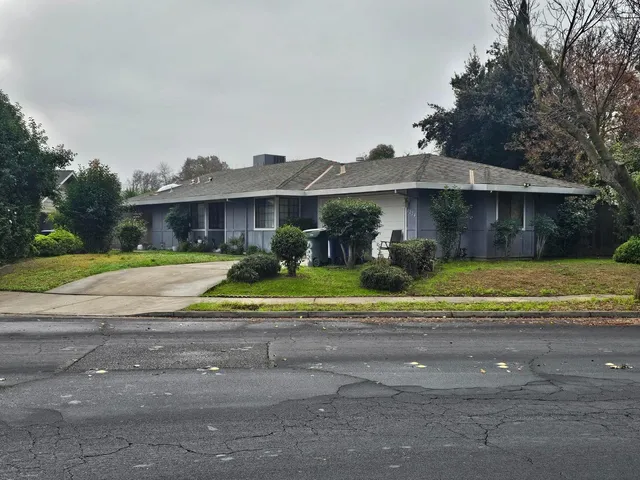 a view of a house with a big yard and large trees
