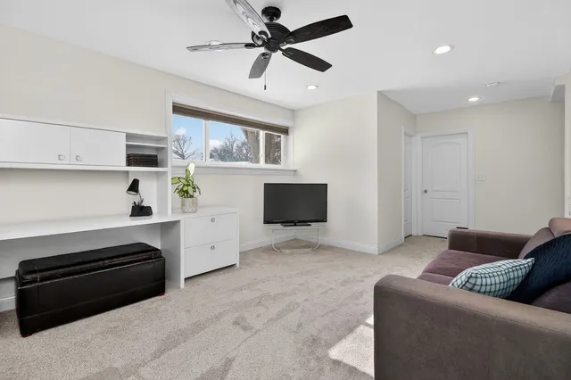 a living room with furniture and a ceiling fan