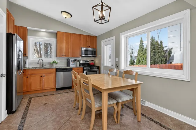 a kitchen with a table chairs sink and cabinets