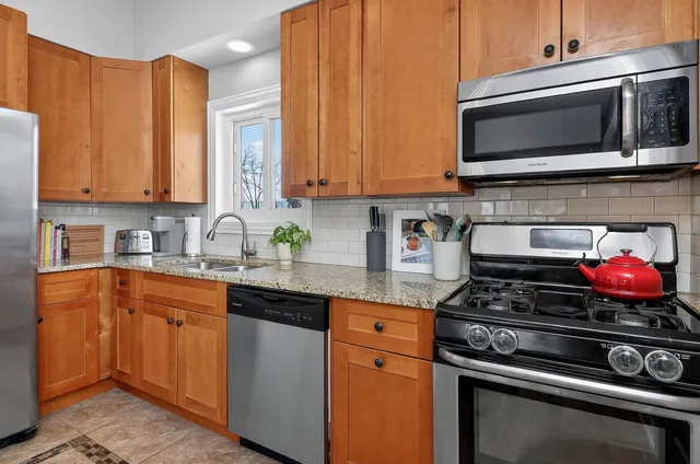 a kitchen with stainless steel appliances granite countertop a stove microwave and cabinets