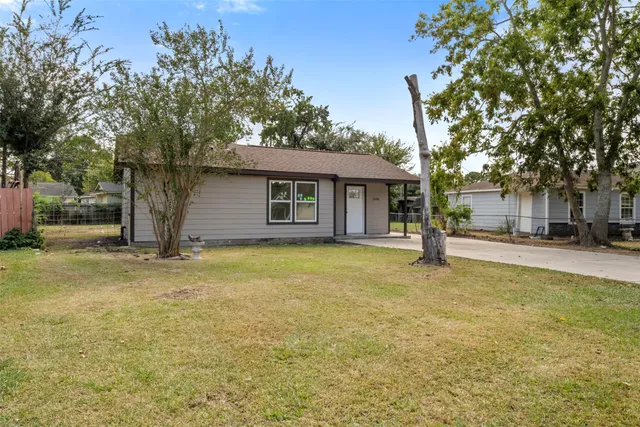 a view of a house with a yard and tree