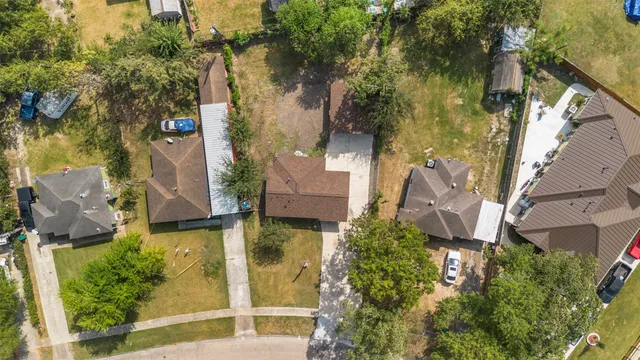 an aerial view of residential houses with outdoor space and trees