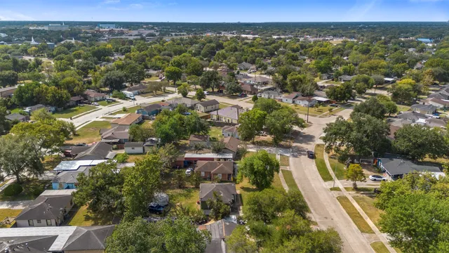 an aerial view of residential houses with outdoor space and trees