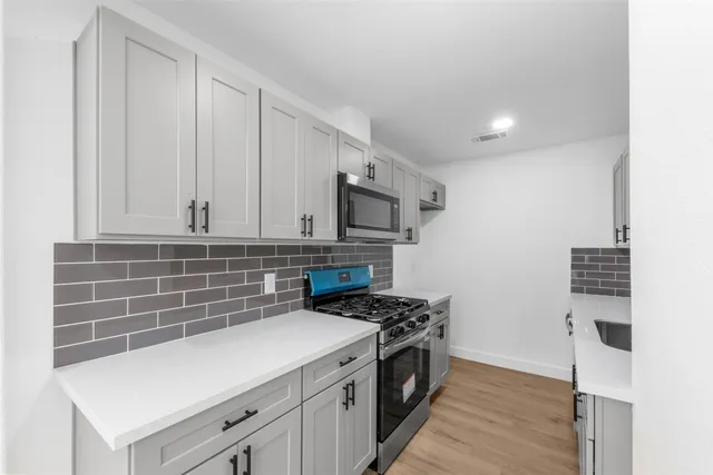 a kitchen with granite countertop a stove and a sink