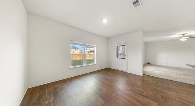 a view of kitchen with microwave a refrigerator and cabinets