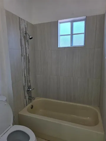 a bathroom with a toilet and a bathtub