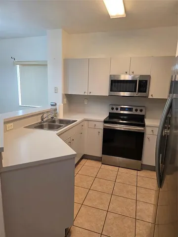 a kitchen with stainless steel appliances a sink stove and refrigerator