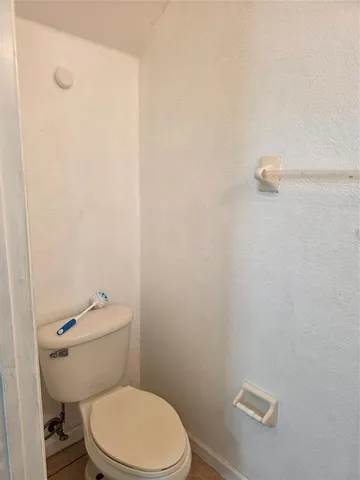 a white toilet sitting next to a shower