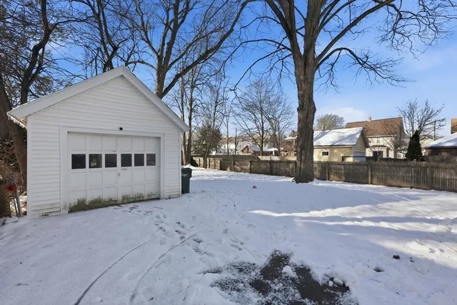 a view of white house with a yard covered with snow