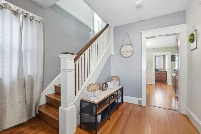 a view of hallway with wooden floor and stairs