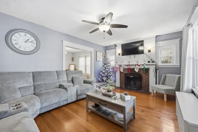 a living room with furniture a clock tv and a window