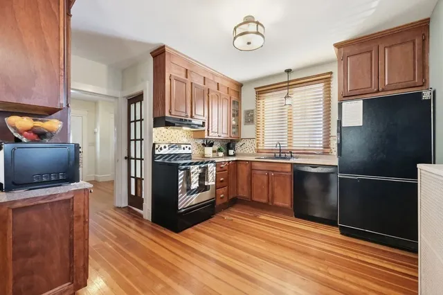 a kitchen with granite countertop a refrigerator stove top oven and sink
