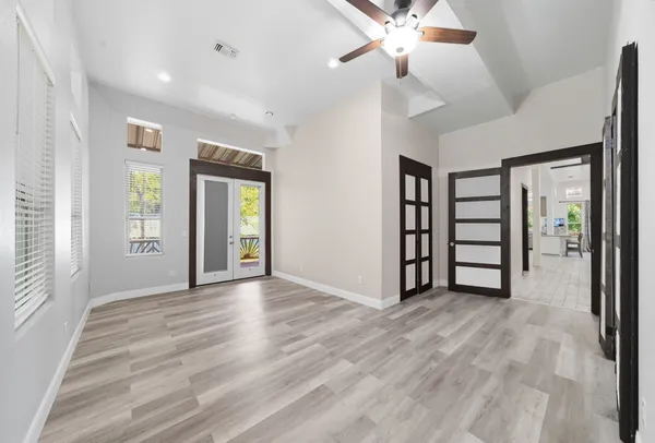 a view of an empty room with window and wooden floor