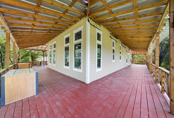 a backyard of a house with a table and chairs under an umbrella