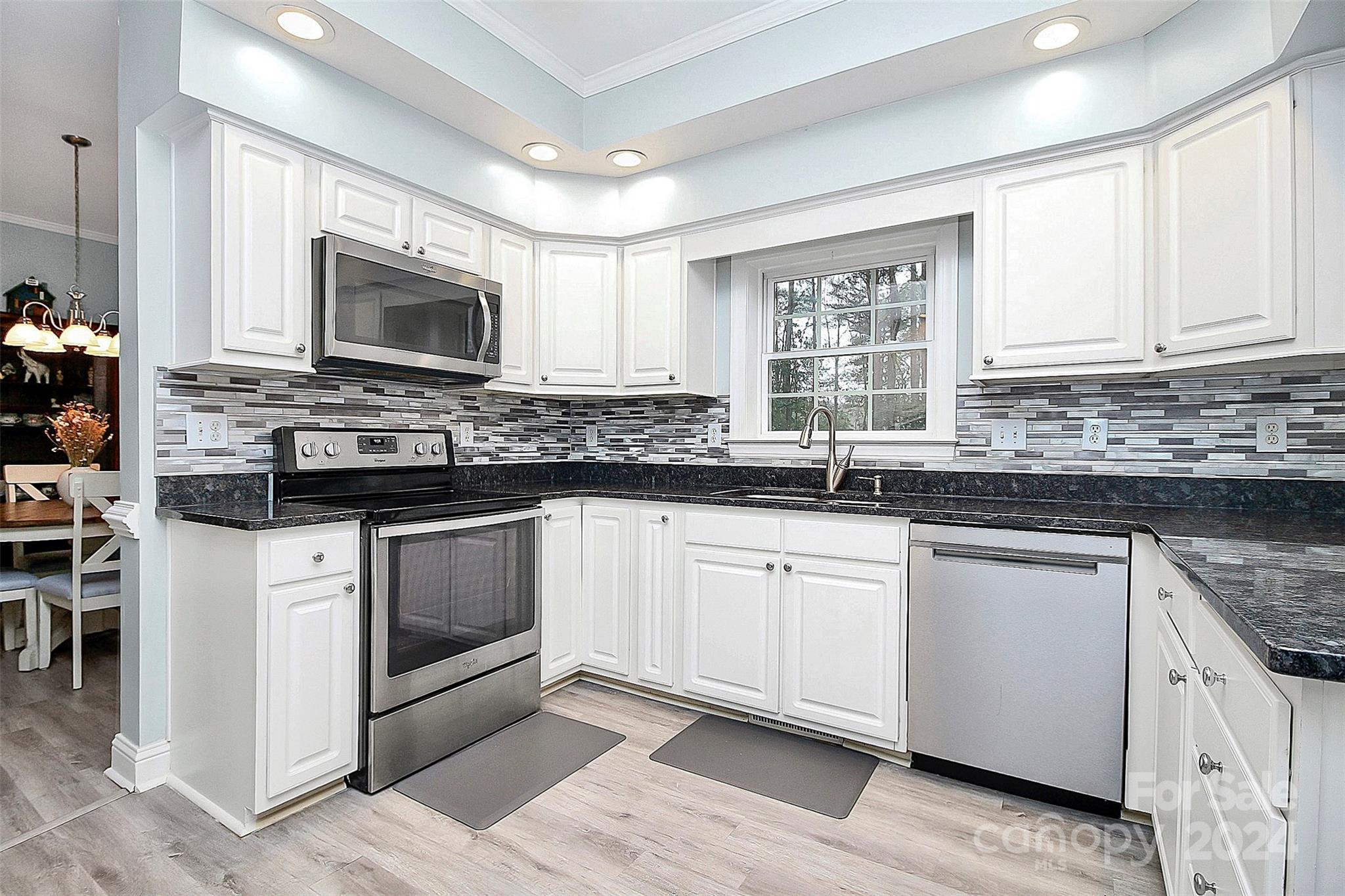 218 Stillwater Road Troutman, NC 28166 - Photo 13 of 43 a kitchen with granite countertop a sink stove and microwave