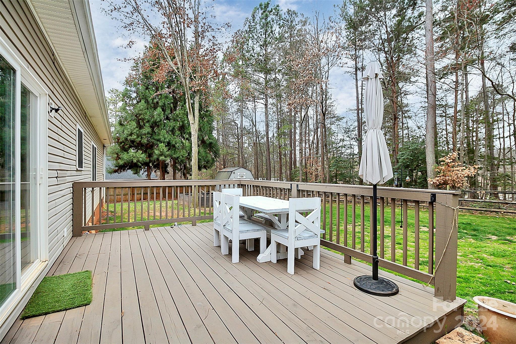 218 Stillwater Road Troutman, NC 28166 - Photo 36 of 43 a view of a deck with chairs and wooden floor next to a yard