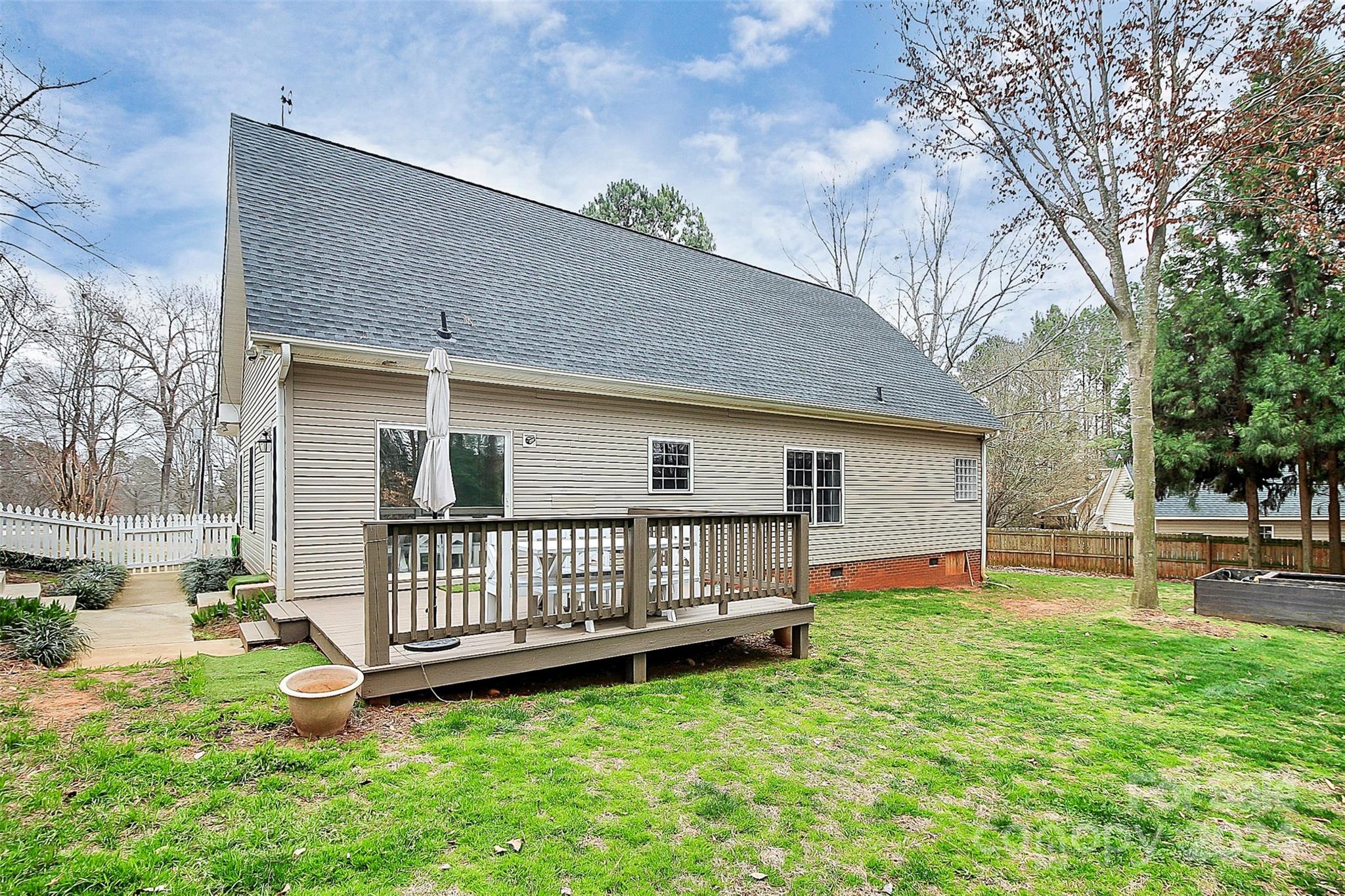 218 Stillwater Road Troutman, NC 28166 - Photo 37 of 43 a view of a house with a yard and deck area with wooden fence