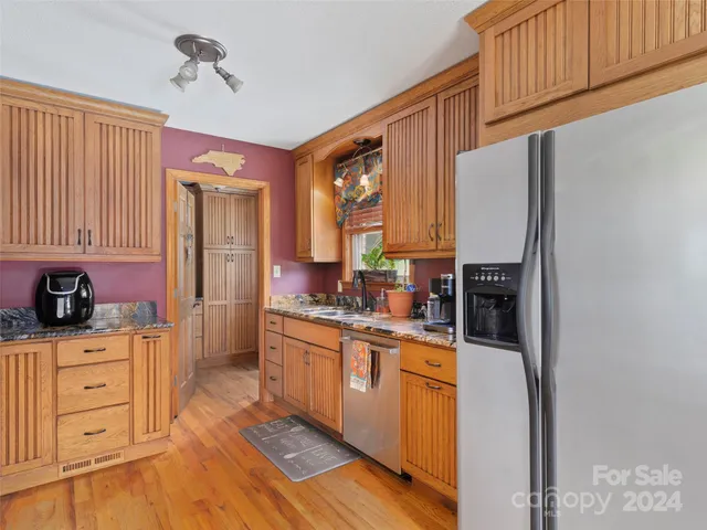 a kitchen with stainless steel appliances a refrigerator sink and cabinets