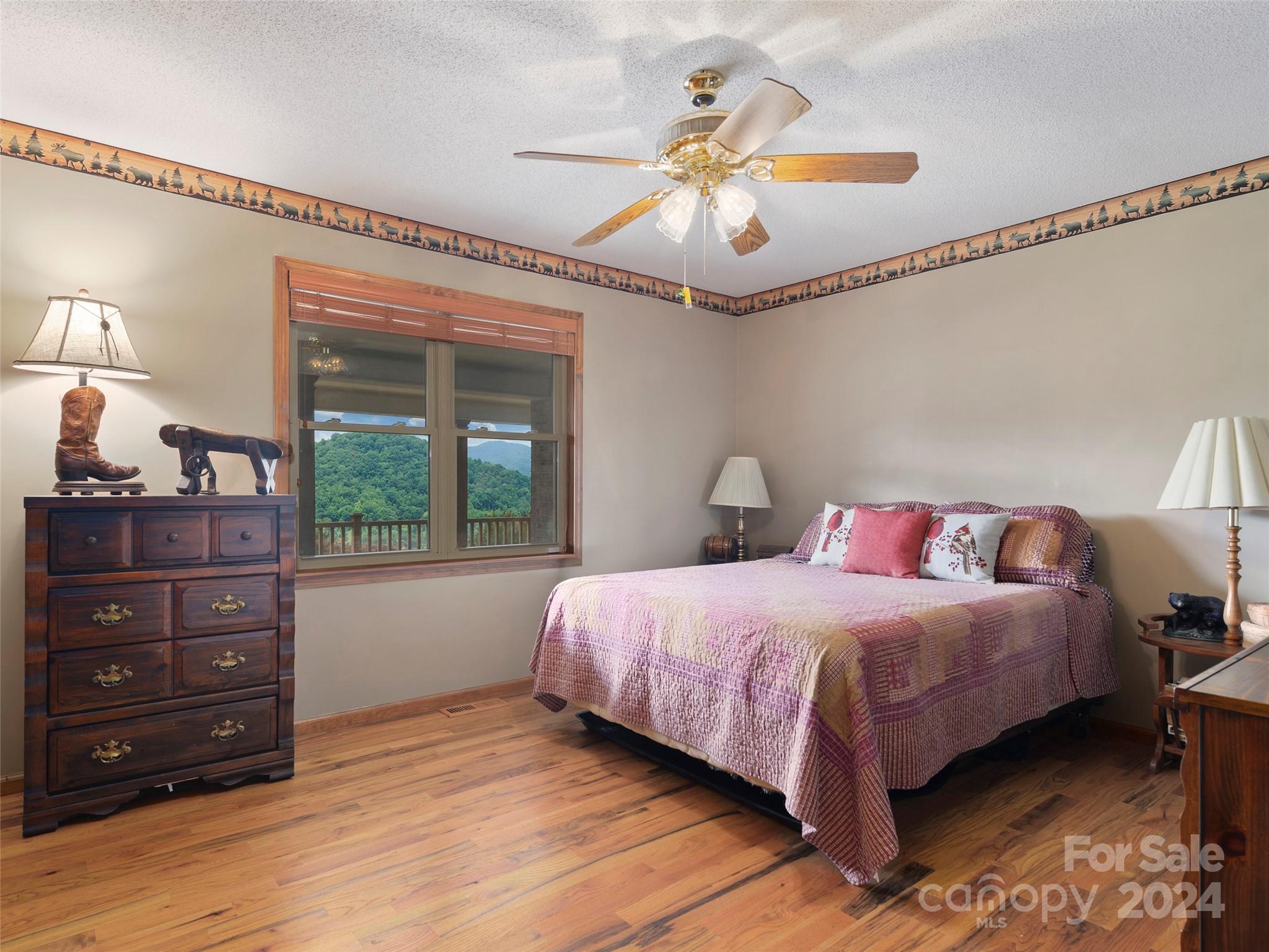 317 Camp Branch Road Clyde, NC 28721 - Photo 16 of 47 a bedroom with a bed and a chandelier