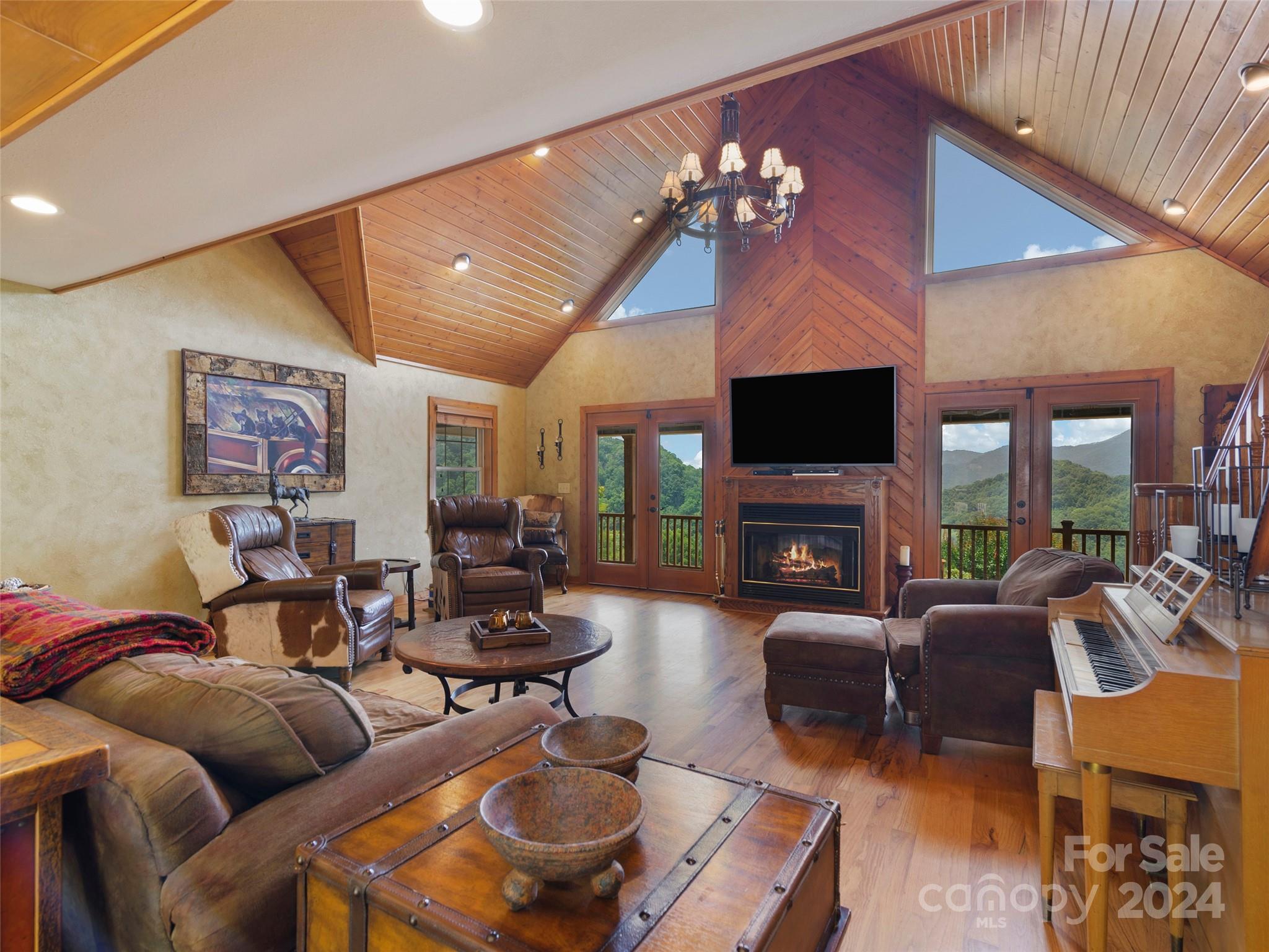 317 Camp Branch Road Clyde, NC 28721 - Photo 37 of 47 a living room with furniture a fireplace and a flat screen tv
