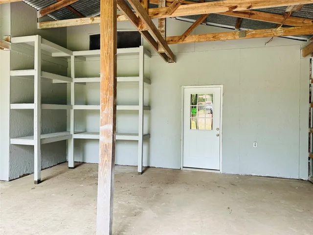 a view of an empty room with a cabinet and a window