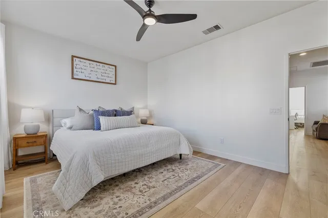 a bedroom with a bed and wooden floor