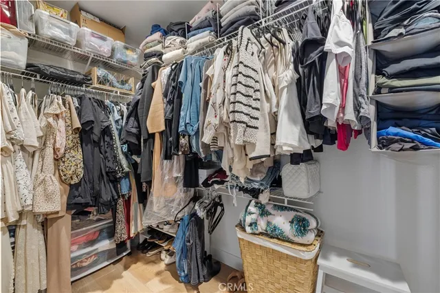 a view of walk in closet with clothes and shoes