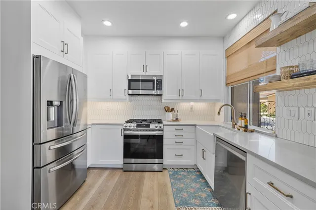 a kitchen with stainless steel appliances granite countertop a refrigerator sink and stove