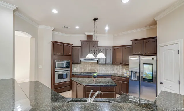 a kitchen with kitchen island cabinets and refrigerator