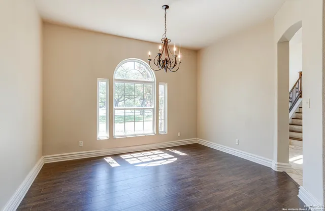 a view of empty room with wooden floor and window
