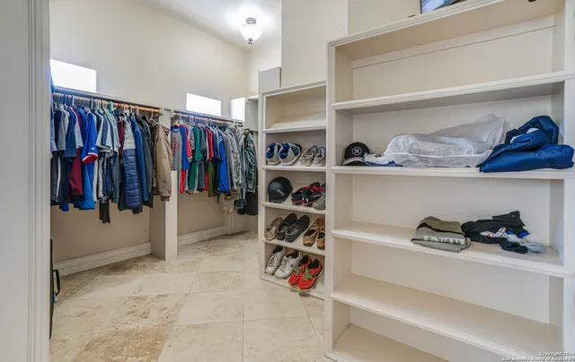 a view of walk in closet with clothes and shoes