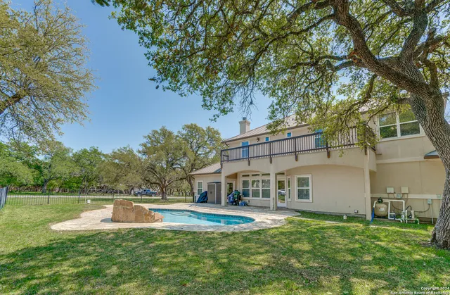 a view of a house with pool and a yard
