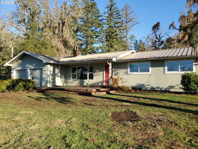 a view of a house with backyard and sitting area