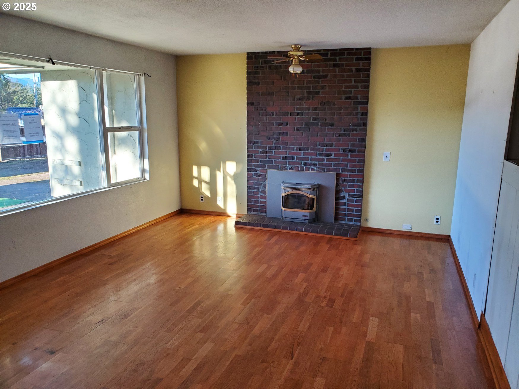 37186 Tree Farm Road Springfield, OR 97478 - Photo 4 of 37 a view of empty room with wooden floor and fireplace