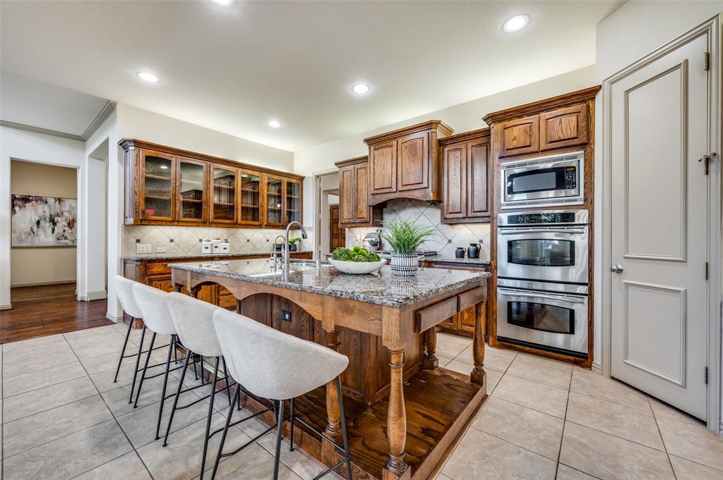 1318 Rio Grande Drive Allen, TX 75013 - Photo 13 of 38 a kitchen with granite countertop a refrigerator and cabinets