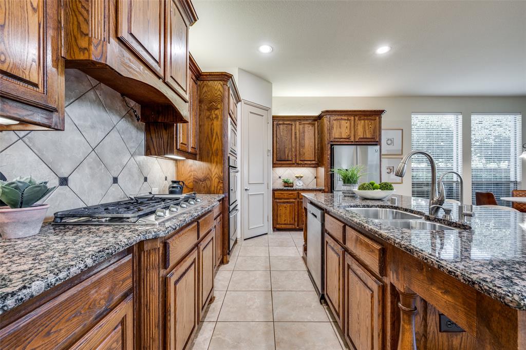 1318 Rio Grande Drive Allen, TX 75013 - Photo 14 of 38 a kitchen with stainless steel appliances granite countertop a sink stove and cabinets