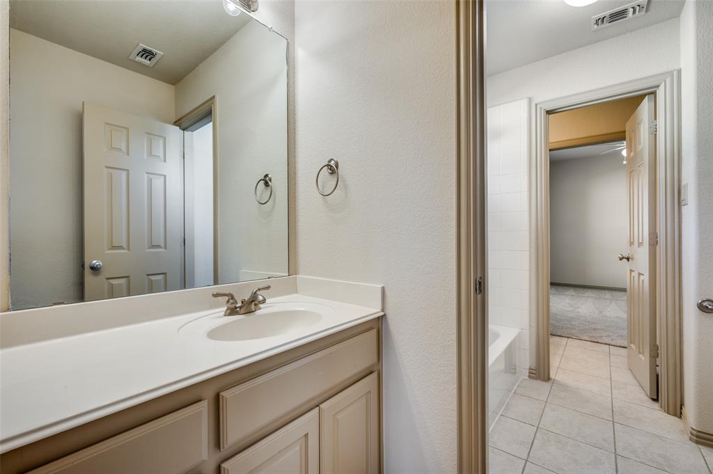 1318 Rio Grande Drive Allen, TX 75013 - Photo 27 of 38 a bathroom with a sink a mirror and a shower