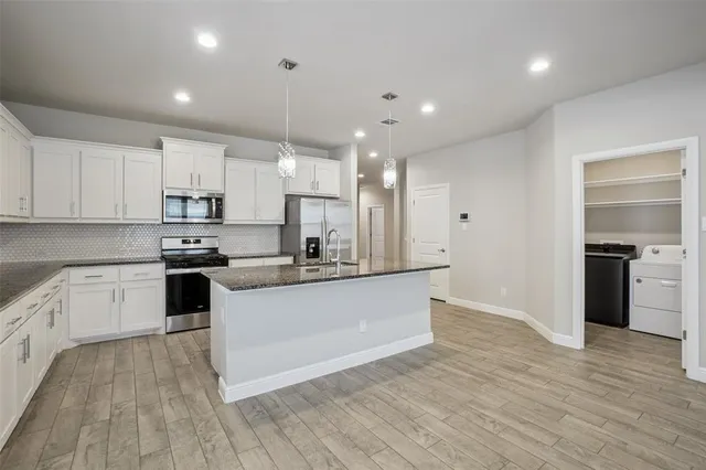 a kitchen with a sink stove and wooden floor