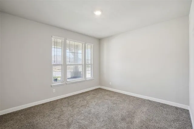 a view of empty room with wooden floor and chandelier