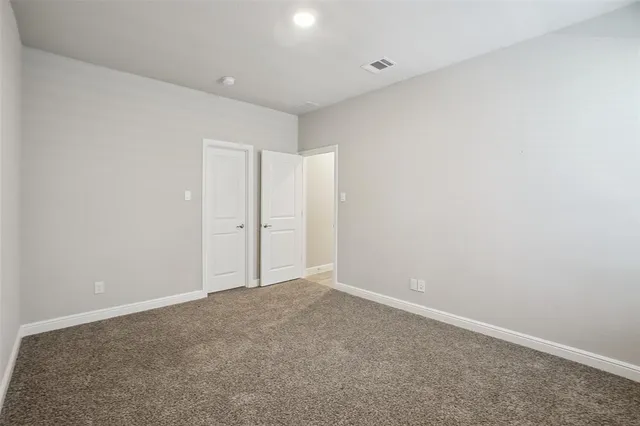 an empty room with closet and a chandelier fan