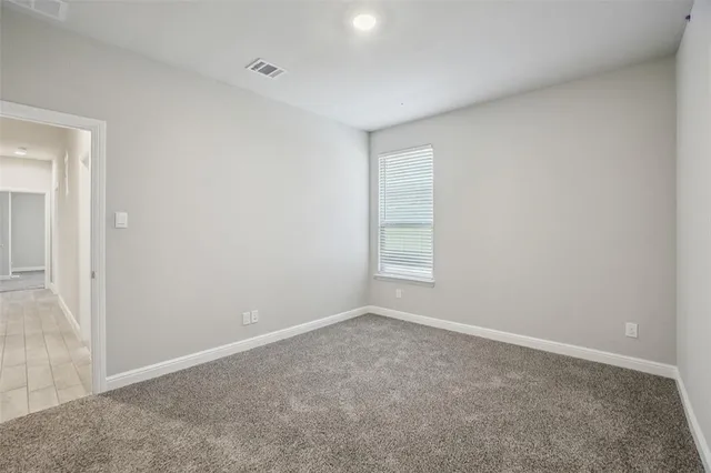 an empty room with a window and a chandelier fan
