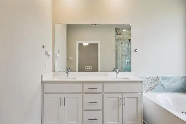 a bathroom with a tub sink shower and mirror
